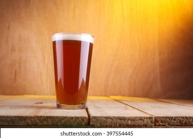 Shaker Glass With Amber Beer On A Grunge Wood Surface