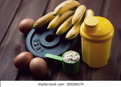 Shaker, measuring scoop with protein, eggs and bananas, close-up