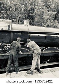 SHAKERSTONE, UK - OCTOBER 19, 2019: Train Crew Polish The Nameplate Of A Vintage Steam Engine On The Battlefield Line