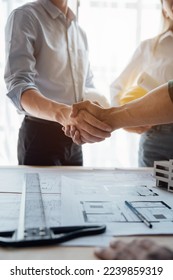 Shaking hands between architect and construction worker engineers working for teamwork and cooperation concept. - Shutterstock ID 2239859319