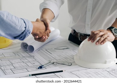 Shaking hands of collaboration, Construction engineering or architect discuss a blueprint while checking information and conference new project plan , contract , success, partnership concept.