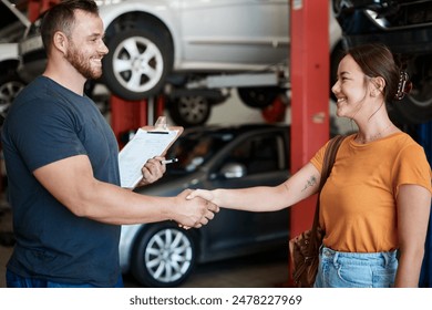 Shaking hands, smile and woman with mechanic in workshop for deal on vehicle repair or maintenance. Clipboard, welcome and Asian person with industrial worker for handshake in garage for car service. - Powered by Shutterstock