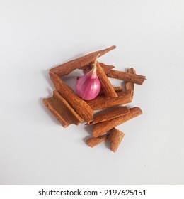 Shallot In The Middle Of Cinnamon Shards Isolated On White Background.