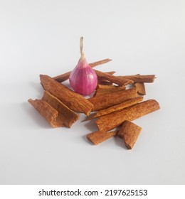 Shallot In The Middle Of Cinnamon Shards Isolated On White Background.