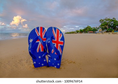 Shallow depth of field Australian flag thongs/flip-flops washed up on a sandy beach 