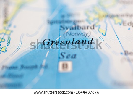 Shallow depth of field focus on geographical map location of Greenland Sea off coast of Greenland on atlas