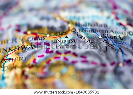 Shallow depth of field focus on geographical map location of Mount Nanga Parbat in Pakistan Asia continent on atlas