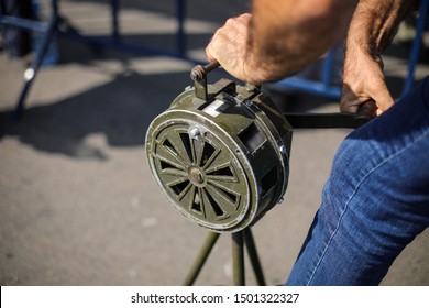 Shallow Depth Of Field Image With A Man Handling A Vintage Hand Crank Air Raid Siren
