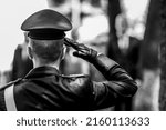 Shallow depth of field (selective focus) details with an Italian policeman in a ceremonial uniform saluting.