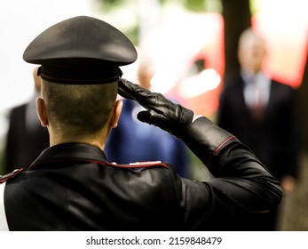 Shallow depth of field (selective focus) details with an Italian policeman in a ceremonial uniform saluting.