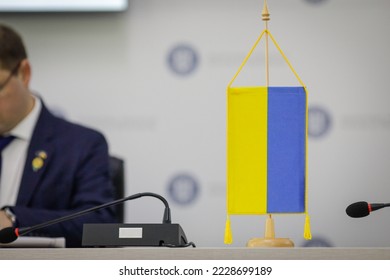 Shallow depth of field (selective focus) details with an Ukrainian flag during a press conference.