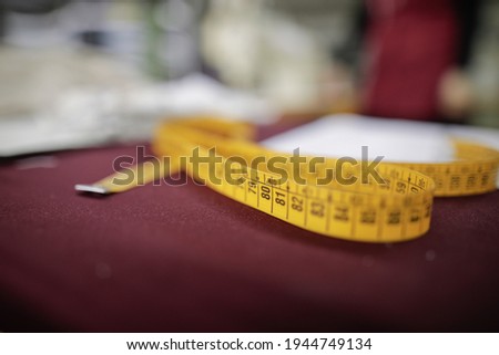 Shallow depth of field (selective focus) image with a tailor’s metre in a textile factory.