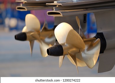Shallow DOF close-up of the boat's double brass propellers.