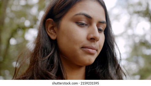 A Shallow Focus Of A Beautiful Indian Woman Against Trees At A Park