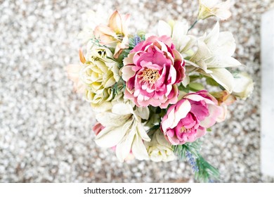 Shallow Focus Of A Bunch Of Artificial Flowers Seen Standing On A Grave In A Cemetery.