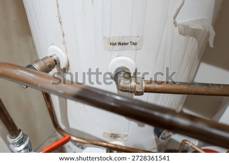 Shallow focus of a copper pipe exiting a typical central heating hot water tank within a home. Shallow focus of a copper pipe exiting a typical central heating hot water tank within a home.