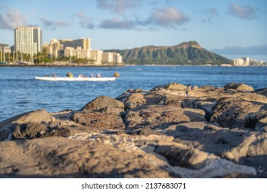 Shallow focus for effect on rocks in the foreground, with the famous Diamond Head and city skyline blurred in the distance, at Ala Moana Beach Park.