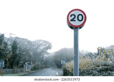 Shallow focus of a frozen 20 Mph speed limit sign seen at the edge rural community.