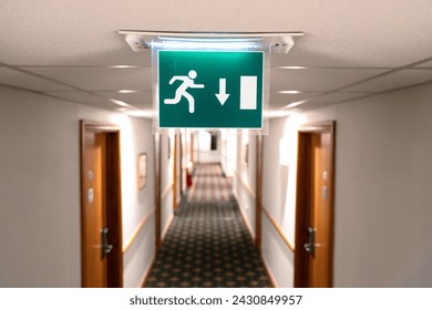 Shallow focus of a generic Fire Escape sign seen hanging from the ceiling of a hotel lobby in europe.
