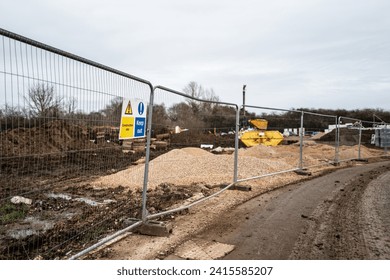 Shallow focus of a Keep Out and Construction Site sign seen on a metal fence on a new housing development in England.