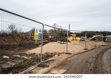 Shallow focus of a Keep Out and Construction Site sign seen on a metal fence on a new housing development in England.