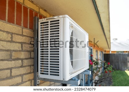 Shallow focus of a large air con unit seen attached to the outside wall of an English hospital in mid summer.