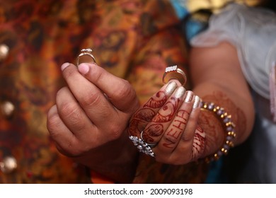 A Shallow Focus Of Male Hand And Female Hand Holding Engaging Rings During Rings Ceremony In India ,henna Hand Tattoo