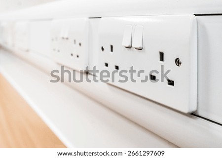 Shallow focus of newly fitted switchable 240 volt electrical sockets seen on a desk in a new office.