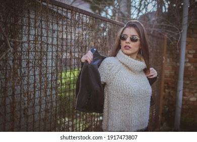 A Shallow Focus Shot Of A Badass Female Standing Beside A Fence