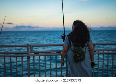 A Shallow Focus Shot Of A Young Woman Looking To The Distance At A Fishing Spot