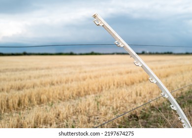 Shallow Focus Of A Stretched And Bend Plastic Electric Fence Post Seen In A Rural Field.