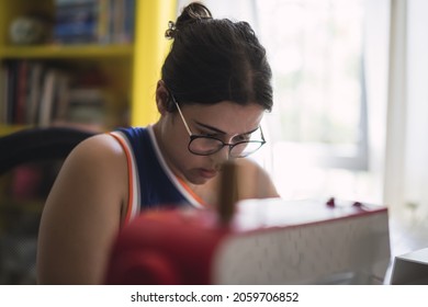 A Shallow Focus Of A Young Spanish Girl Sewing Indoors