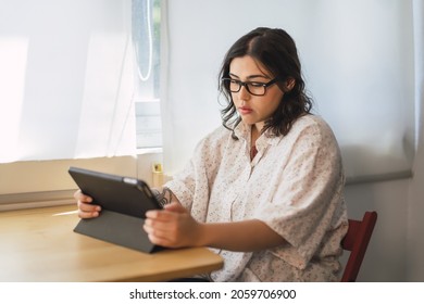 A Shallow Focus Of A Young Spanish Girl Using A Tablet Indoors