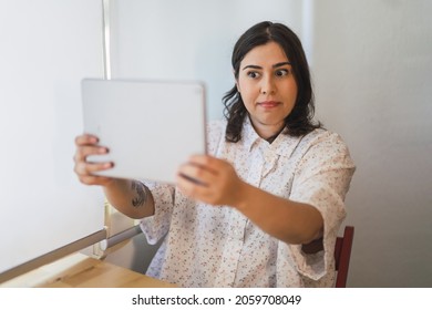 A Shallow Focus Of A Young Spanish Girl Using A Tablet Indoors