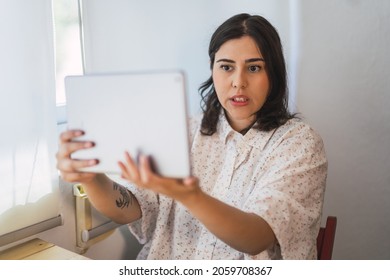 A Shallow Focus Of A Young Spanish Girl Using A Tablet Indoors