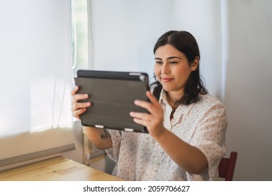 A Shallow Focus Of A Young Spanish Woman Using A Tablet Indoors