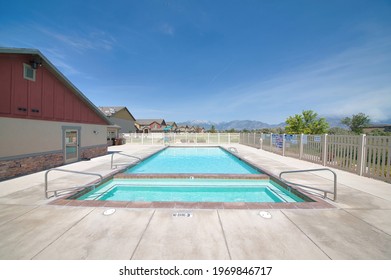 Shallow And Full Size Pool For Adults And Kids With Mountain And Sky View. Community Swimming Pool With Neighborhood Houses And Scenic Nature Landscape In The Background.