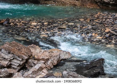 Shallow turquoise water rapids at the base of Johnston Canyon's upper falls in Banff, Alberta, Canada, August 2020. 