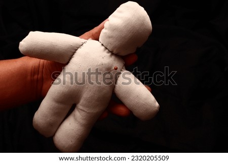 A shaman places a needle on the cotton doll's heart to curse him of death. This image fits well with an ancient ritual treatise.