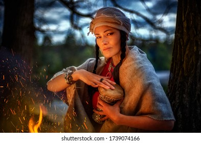 Shaman, woman with a tambourine by the fire, evening ritual
 - Powered by Shutterstock