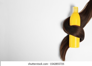 Shampoo Bottle Wrapped In Lock Of Hair Isolated On White, Top View. Natural Cosmetic Products