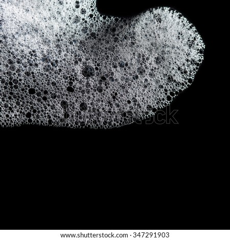 Shampoo bubbles. Soapy foam, suds, spume, shower texture. Black background. close-up