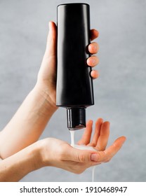 Shampoo, Hair Rinse Is Poured From A Black Tube Into A Woman's Hand. An Empty Tube With A Place For The Logo.