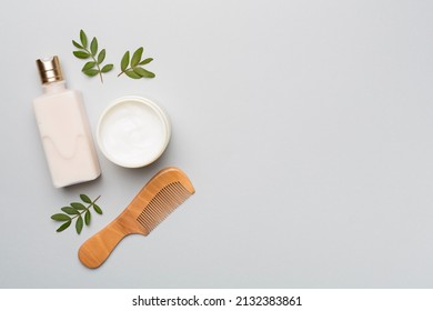 Shampoo and mask with herbal extract and comb on color background, top view. - Shutterstock ID 2132383861