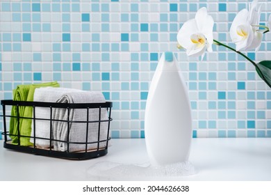 Shampoo On A White Tile Background. Shower Gel With Orchids In The Bathroom. Cosmetics For Skin Health. Mockup For Your Logo. Bath Mockup With Copy Space.  Bottle Of Shampoo Or Shower Gel