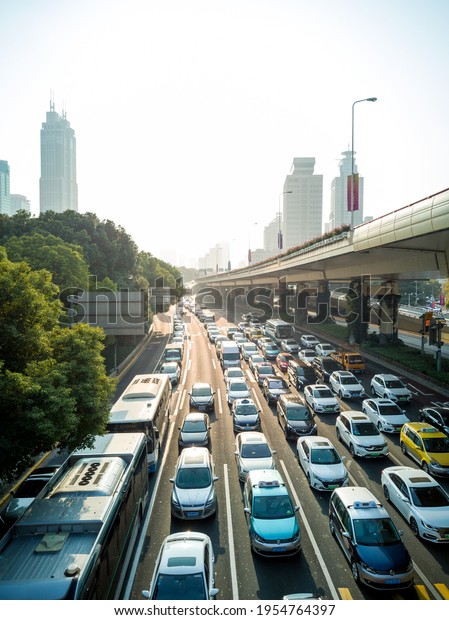 Shanghai, China -\
06.11.2019: Streets full of cars in downtown shanghai with heavy\
car traffic on the city highway with skyscraper in the background\
ans seunset light\
streets