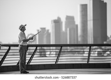 SHANGHAI, CHINA, 23 September 2016. Local Chinese Man Flying Kite Along The Bund In Shanghai, China. Black And White Street Photography. 