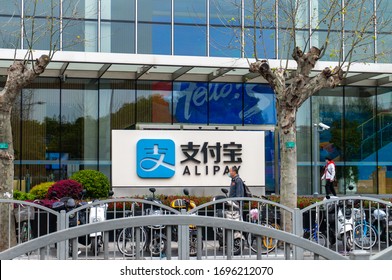Shanghai, China - Apr 6, 2020: People wearing face mask walk along the Alipay building in Shanghai's Lujiazui Financial City during the pandemic period. Alipay  is a unit of Ant Financial Services
