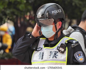 Shanghai, China - April 15, 2020: Close Up Portrait Of Policeman Wearing Face Mask And High Tech Helmet Monitoring The Temperature Of Pedestrians On Nanjing Road.