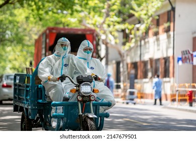 Shanghai, China - April 17 2022: Workers In Protective Gear Drive Past A Food Distribution Truck As Shanghai's COVID-19 Lockdown Continues With Officials Scrambling To Organise Food For 23m People.